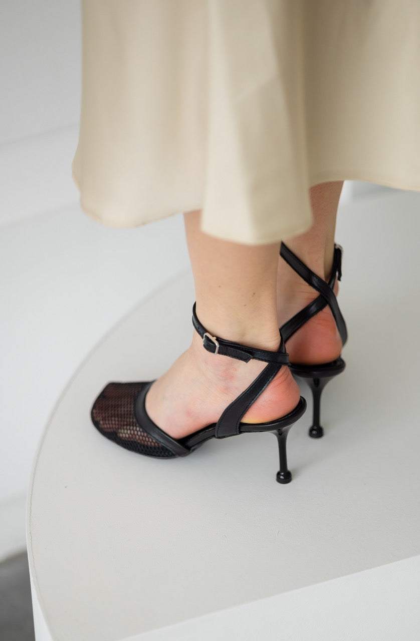 Black dressy sandals featuring breathable mesh and leather details