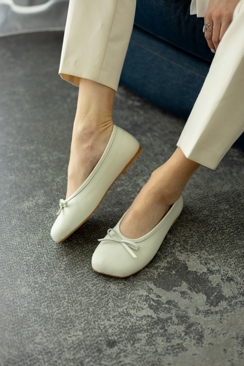 Minimalist leather flats with decorative bow front view