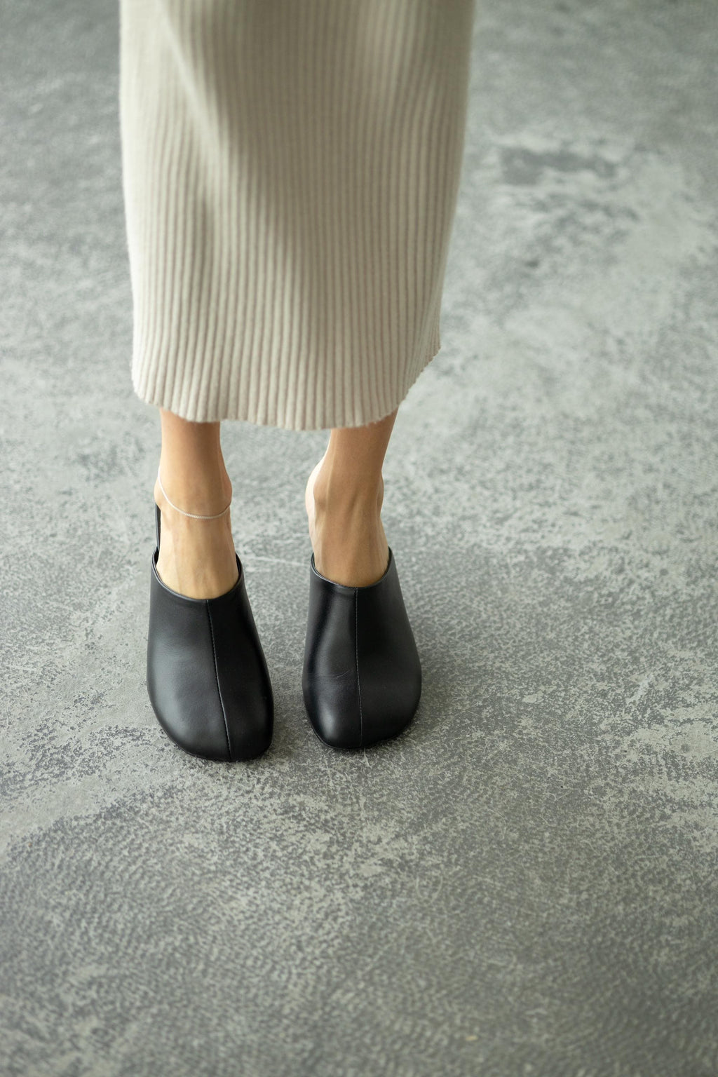 Open back leather heels on feet