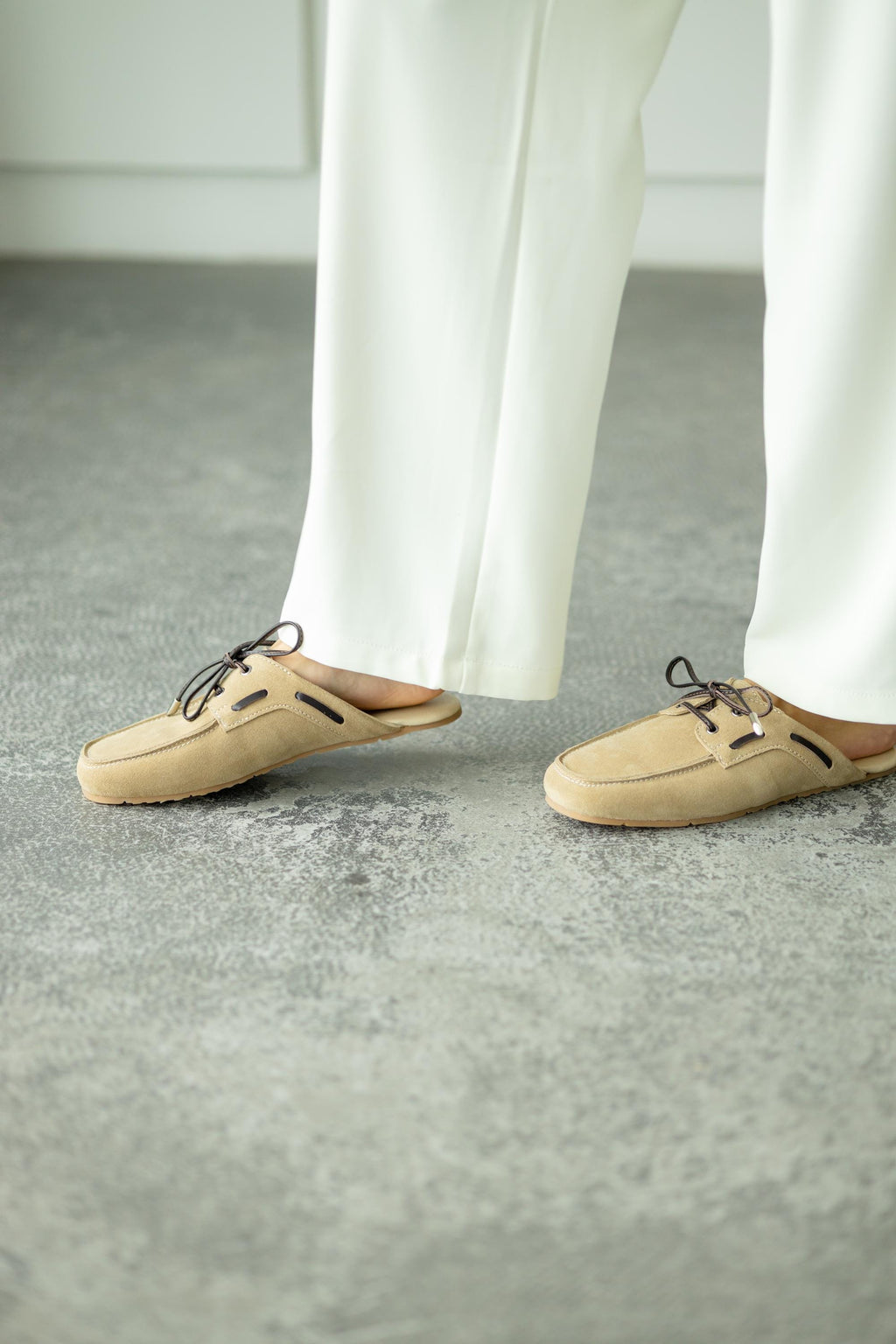 Beige suede backless loafers with decorative lacing front view
