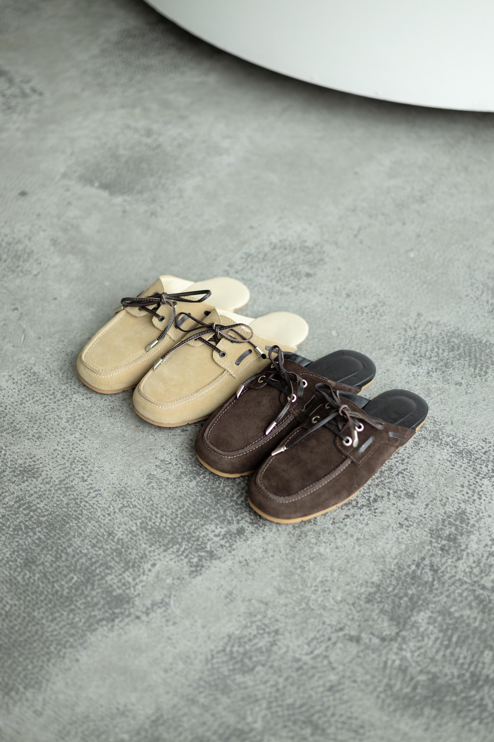 Decorative lacing detail on beige suede slip-on loafers