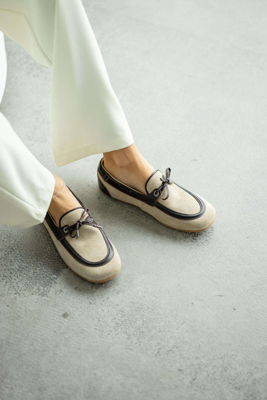 Beige suede backless loafers with decorative lacing front view