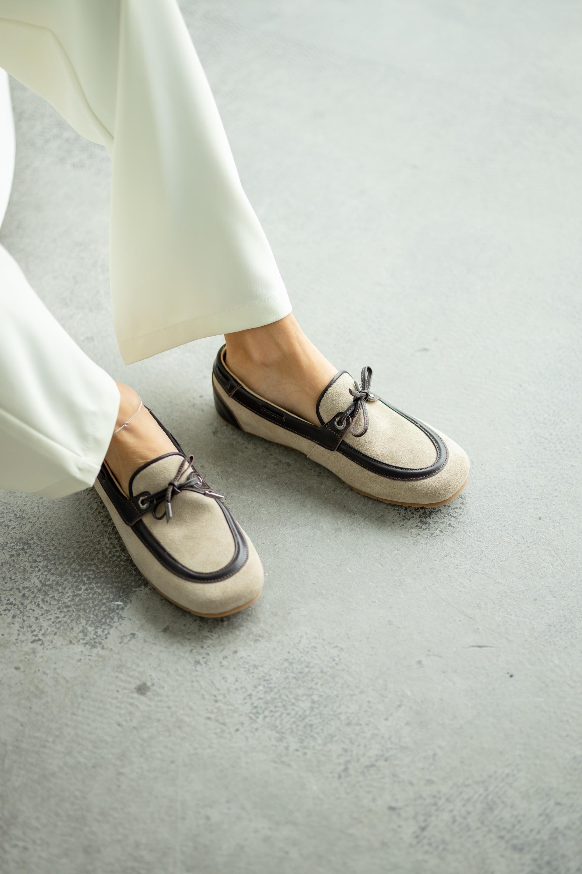 Beige suede backless loafers with decorative lacing front view