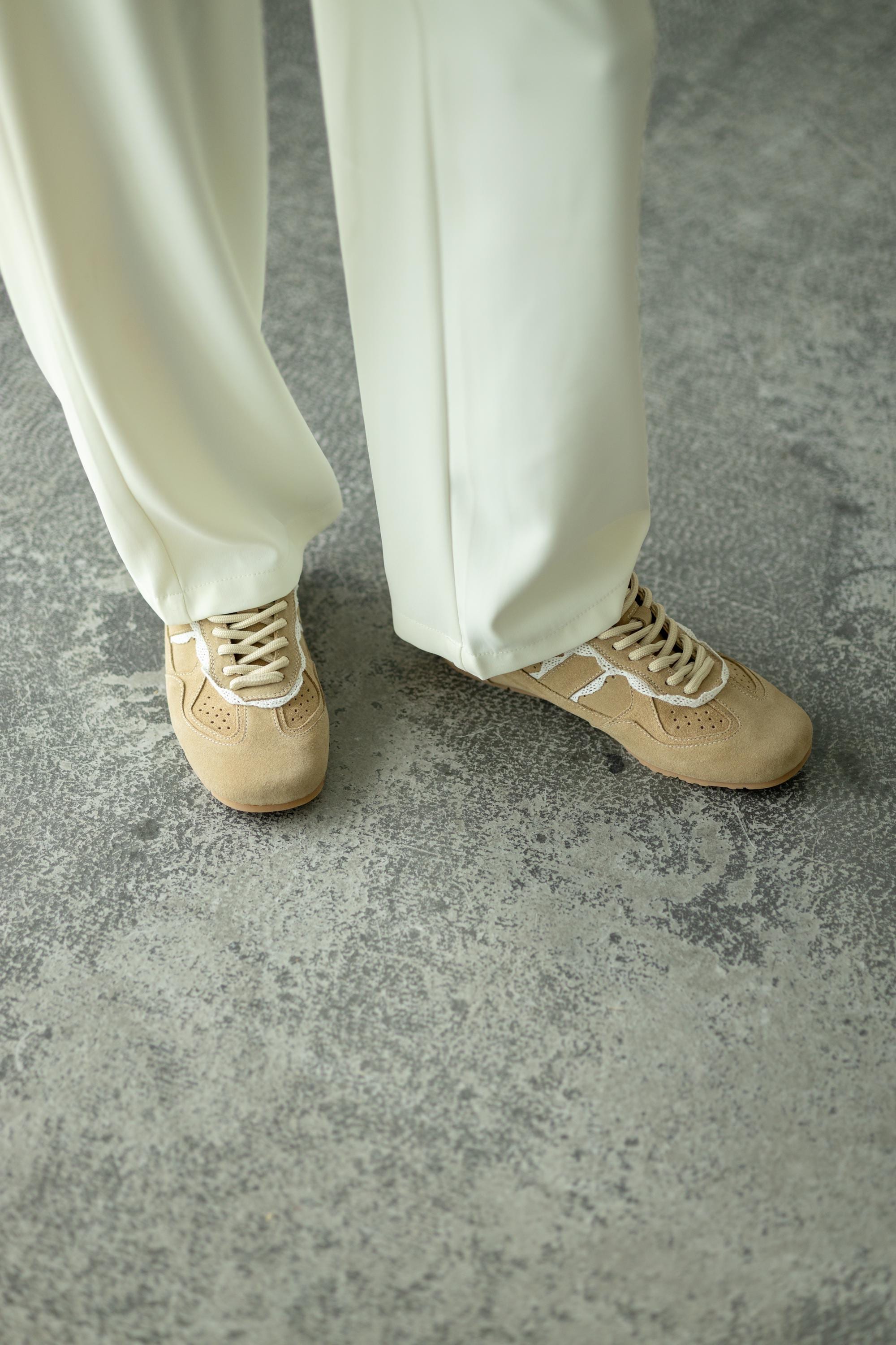 Light beige suede sneakers lace inserts close-up